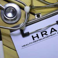 Health Reimbursement Account (HRA) text on Document form isolated on office desk. Health Reimbursement Account (HRA) text on Document form isolated on office desk.