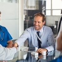 Salesman shaking hands with doctor Salesman shaking hands with doctor