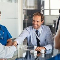 Salesman shaking hands with doctor