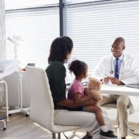Mother And Daughter In Consultation With Doctor In Office Mother And Daughter In Consultation With Doctor In Office