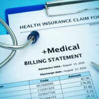 Healthcare cost concept with medical bill and health insurance claim form