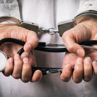 Handcuffed doctor. Medical crime concept, closeup Handcuffed doctor. Medical crime concept, closeup