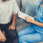 A young female doctor inquires about personal information of a contented senior at home. Medical care for the elderly, elderly illness, and nursing homes, home care.