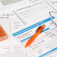 Surgery bills with health insurance claim calculator and pen Surgery bills with health insurance claim calculator and pen