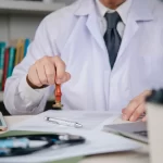 Doctor approval Physician stamps consent on medical document at hospital office to finalize signature and ensure healthcare compliance, updating records for safe treatment. concept policy and trust.